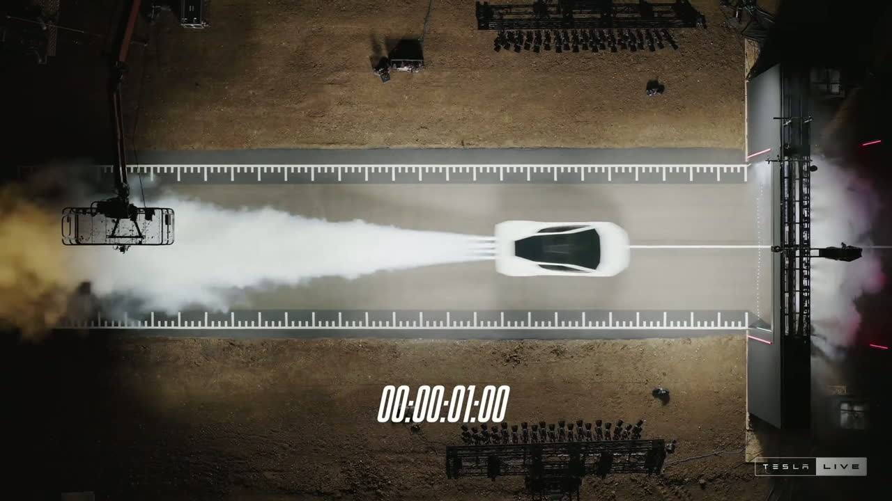 Overhead view of the Roadster launching down a marked strip, a white plume of thruster vapor behind it, timer at one second